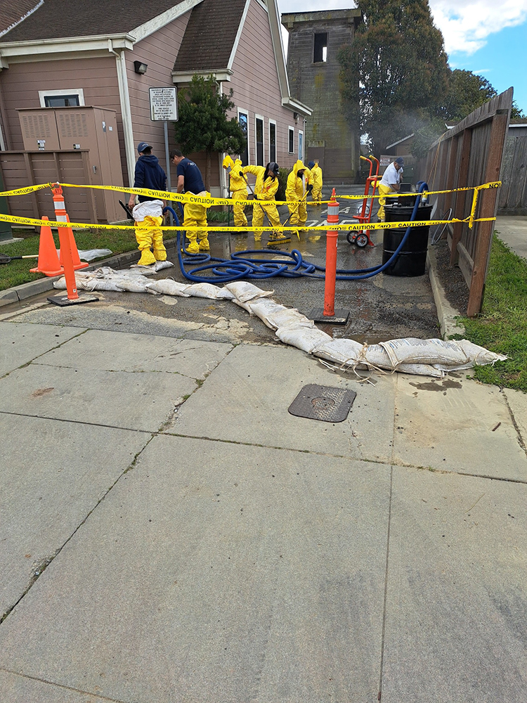 Workers in hazmat suits cleaning up a spill.