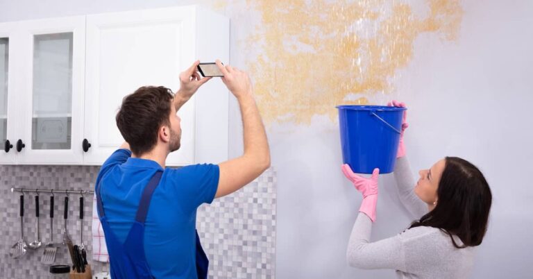 Restoration professional taking pictures of water damage in a house | ATI Restoration