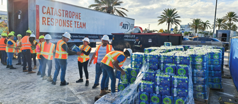 Disaster response team members unloading pallets of bottled water.